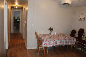 Dining space featuring dark wood-style floors and baseboards