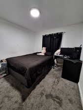 Carpeted bedroom with a desk