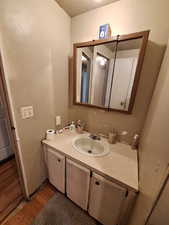 Bathroom with vanity, wood finished floors, and a textured ceiling