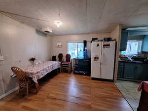 Dining space featuring light wood-style floors and a textured ceiling