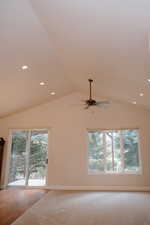 Unfurnished room featuring plenty of natural light, vaulted ceiling, recessed lighting, carpet, and a ceiling fan