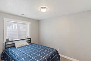 Carpeted bedroom with a textured ceiling