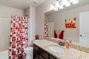 Bathroom with shower / tub combo with curtain and vanity
