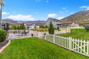 Fenced backyard with a mountain view, a patio, and a residential view