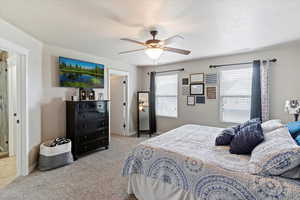 Bedroom with light carpet and a ceiling fan