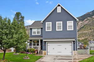 Traditional-style home with covered porch, stucco siding, an attached garage, driveway, and roof with shingles