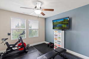 Exercise room featuring baseboards and ceiling fan
