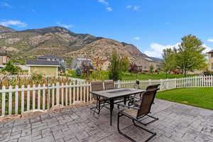 Fenced backyard featuring outdoor dining area, a mountain view, a patio area, and a residential view