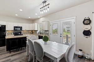 Dining room with dark wood-type flooring, french doors, and recessed lighting
