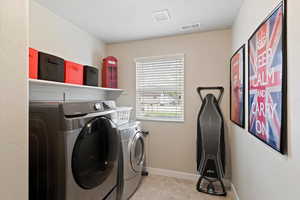 Laundry area with washer and dryer and light tile patterned floors