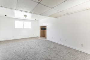 Family room with carpet floors and a drop ceiling