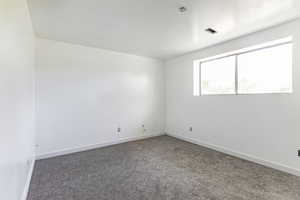 Bedroom #3 featuring carpeting, baseboards, and window.