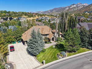 Aerial perspective of suburban area with a mountain backdrop and a tree filled landscape