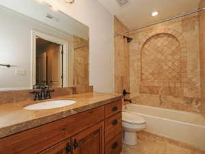 Bathroom featuring shower / tub combination, vanity, light tile patterned floors, and recessed lighting