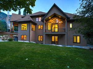 Rear view of house featuring a patio, a balcony, and a yard
