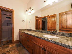 Bathroom featuring double vanity and baseboards