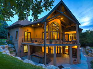 Back of property featuring a patio area, a hot tub, roof with shingles, and stucco siding