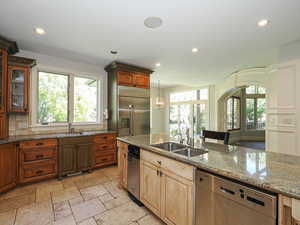 Kitchen featuring dark stone countertops, appliances with stainless steel finishes, recessed lighting, glass insert cabinets, and decorative backsplash