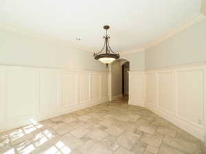 Detailed view of a decorative wall, arched walkways, crown molding, and wainscoting