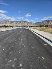 View of asphalt street featuring a mountain view and curbs