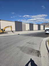 View of asphalt street with curbs, sidewalks, and a mountain view