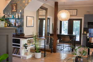 Dining area featuring french doors, light wood-style floors, crown molding, and wine cooler