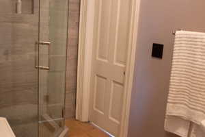 Bathroom featuring a shower stall and light wood finished floors
