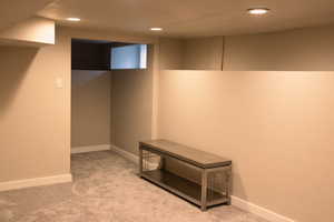 Finished below grade area featuring light carpet and recessed lighting