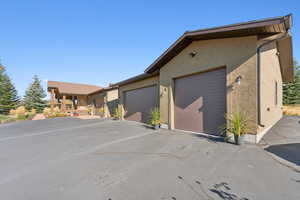 View of front of home featuring stucco siding, driveway, and a garage