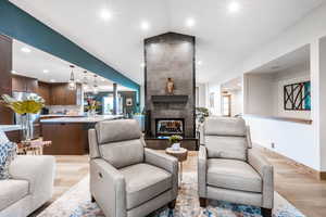 Living area with recessed lighting, light wood-style flooring, and a tiled fireplace