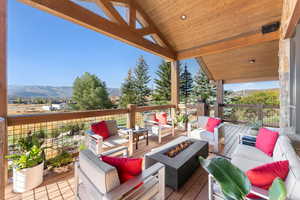 Deck featuring an outdoor living space with a fire pit and a mountain view