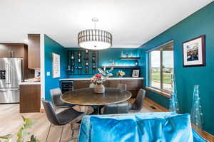 Dining space featuring light wood finished floors and beverage cooler