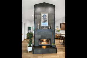 Detailed view of wood finished floors, a tile fireplace, and tasteful backsplash