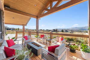 Deck featuring an outdoor living space with a fire pit and a mountain view