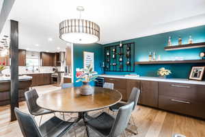 Dining area featuring light wood-style flooring, beverage cooler, and recessed lighting