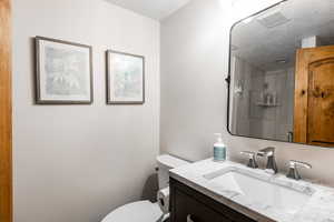 Bathroom with vanity, a stall shower, a textured ceiling, and a textured wall