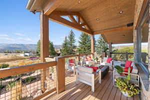 Wooden deck with an outdoor living space with a fire pit and a mountain view