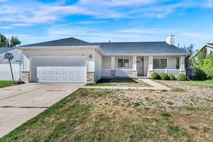 Single story home with covered porch, driveway, a garage, roof with shingles, and a chimney