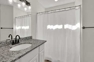 Full bathroom with vanity and curtained shower