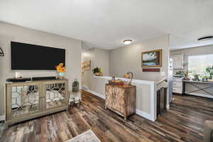 Living room featuring dark wood finished floors and a textured ceiling