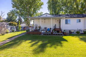Rear view of house featuring a wooden deck and an outdoor living space