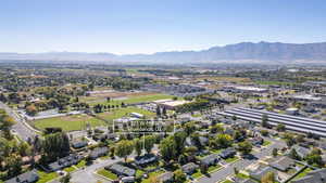 Aerial view of property and surrounding area with a mountain backdrop and nearby suburban area