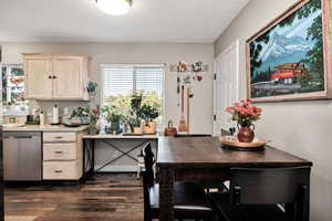 Kitchen with light brown cabinetry, dishwasher, and dark wood-type flooring
