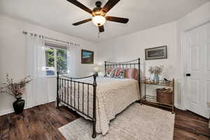 Bedroom with ceiling fan and dark wood-style floors