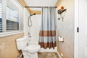 Bathroom with shower / bath combo with shower curtain and tile patterned floors