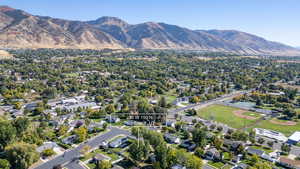 Aerial view of property and surrounding area featuring a mountain backdrop and nearby suburban area