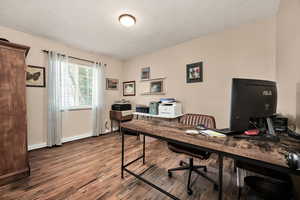 Office space with a textured ceiling and dark wood-style floors