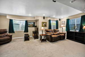 Carpeted living room with baseboards and recessed lighting