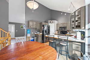 Kitchen featuring vaulted ceiling, a peninsula, backsplash, and stainless steel appliances
