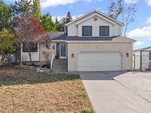 View of front of property featuring driveway, an attached garage, and brick siding